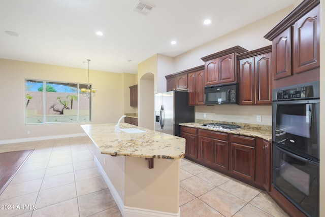 kitchen with sink, black appliances, decorative light fixtures, light tile patterned floors, and light stone countertops