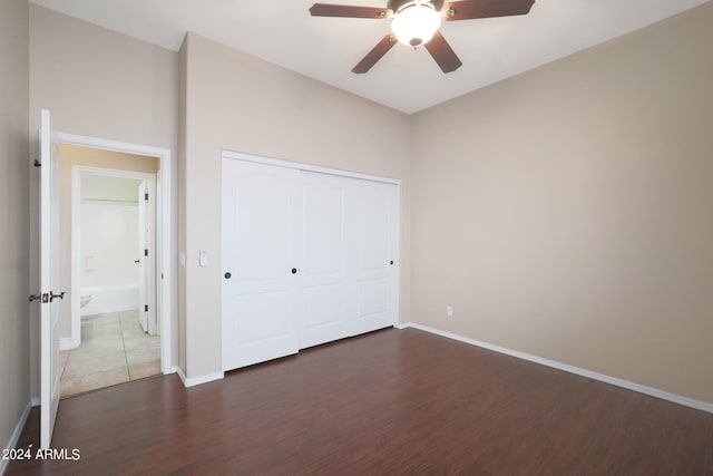 unfurnished bedroom featuring a closet, ceiling fan, and dark wood-type flooring