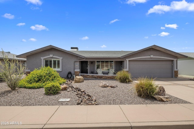 ranch-style house with a garage, driveway, and stucco siding