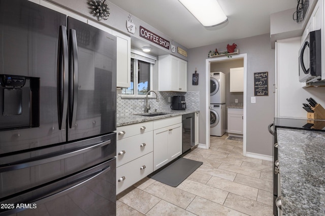 kitchen featuring white cabinetry, fridge with ice dispenser, black microwave, and stacked washer / dryer