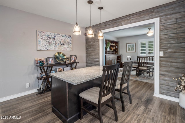 dining room featuring dark wood-type flooring and baseboards