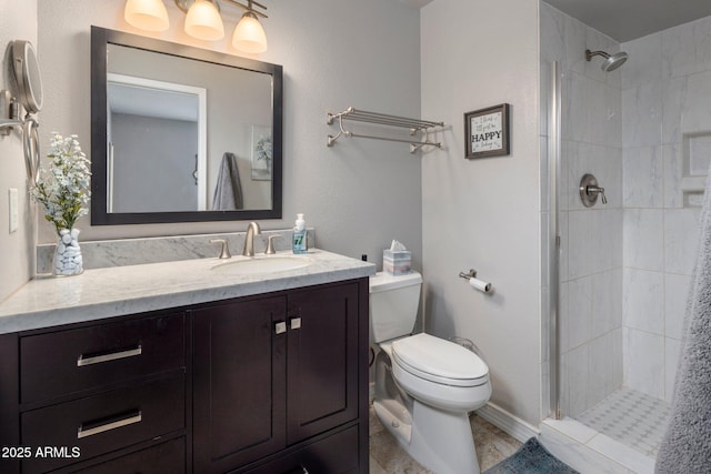 bathroom with tiled shower, vanity, and toilet