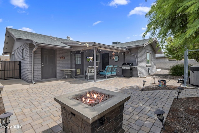 back of house with an outdoor fire pit, roof with shingles, fence, and a patio