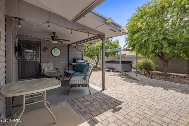 view of patio / terrace with a fenced backyard, ceiling fan, and a hot tub