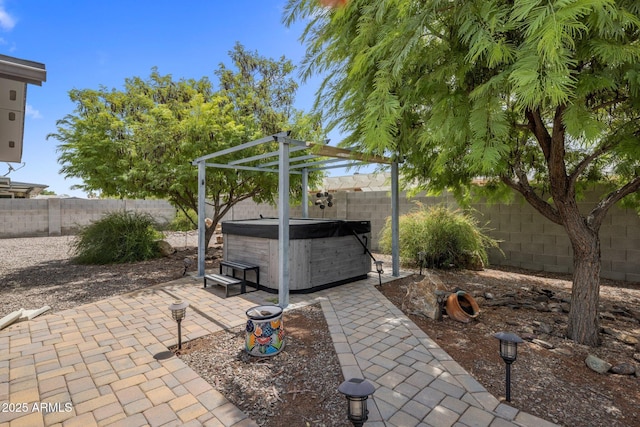 view of patio / terrace with a hot tub, a pergola, and a fenced backyard