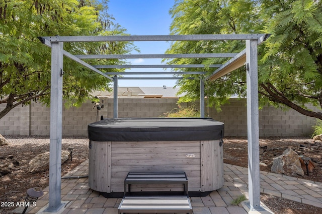 view of patio / terrace featuring a fenced backyard, a hot tub, and a pergola