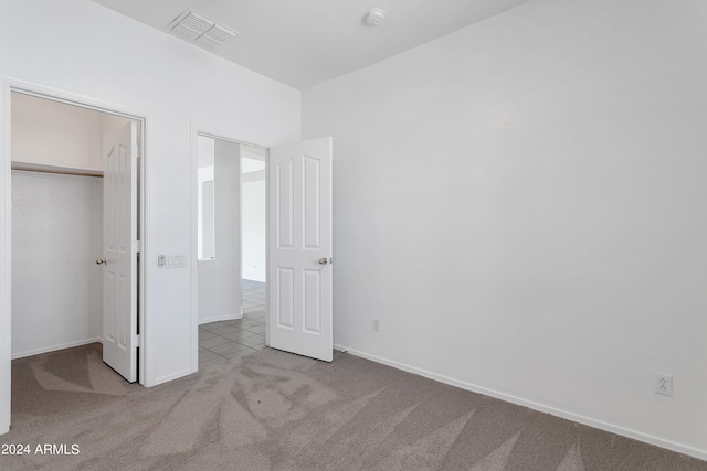 unfurnished bedroom featuring a closet and light carpet