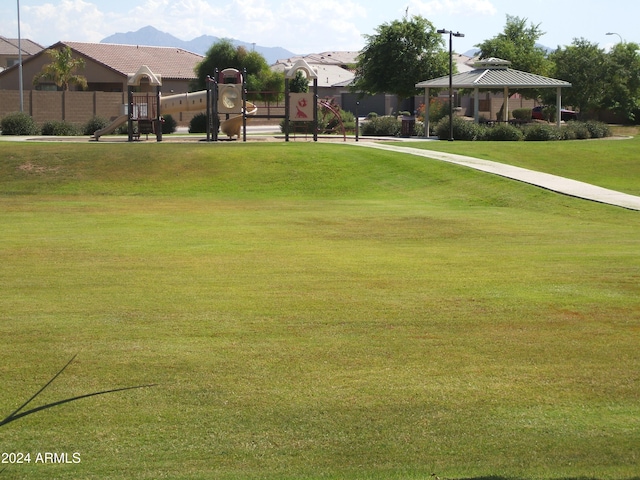 surrounding community with a mountain view, a gazebo, a lawn, and a playground