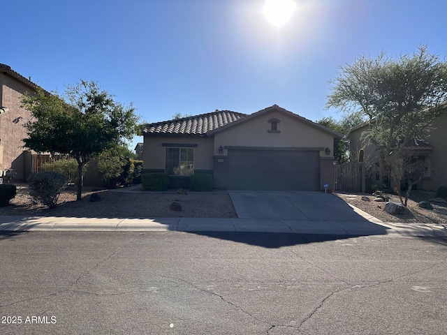 ranch-style home featuring a garage, fence, concrete driveway, and stucco siding