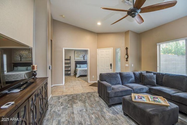 living room with ceiling fan, baseboards, and wood finished floors