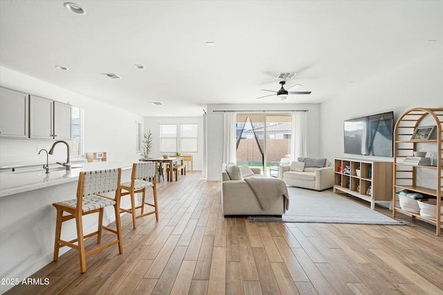 living room with ceiling fan and sink