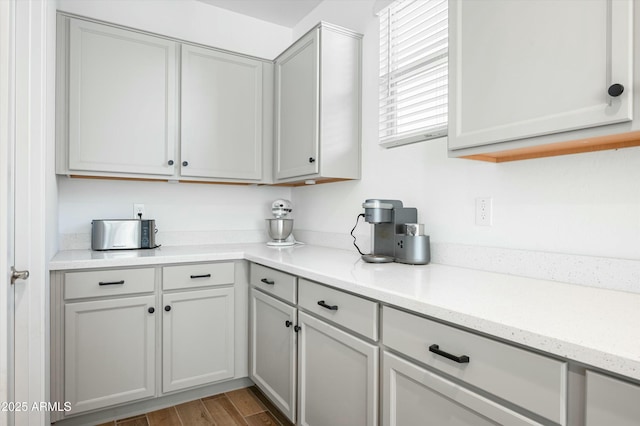 kitchen with gray cabinetry and light stone countertops