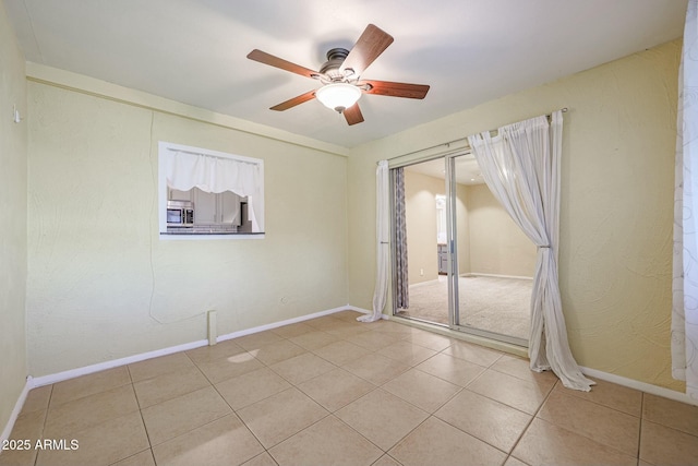 spare room featuring light tile patterned floors and ceiling fan