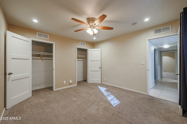 unfurnished bedroom with ceiling fan and light colored carpet