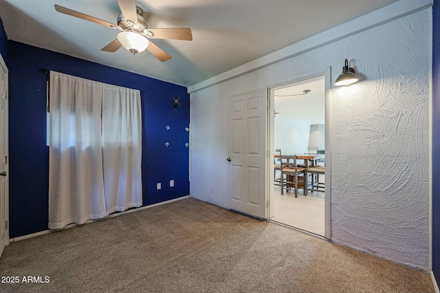 unfurnished bedroom with light carpet and ceiling fan