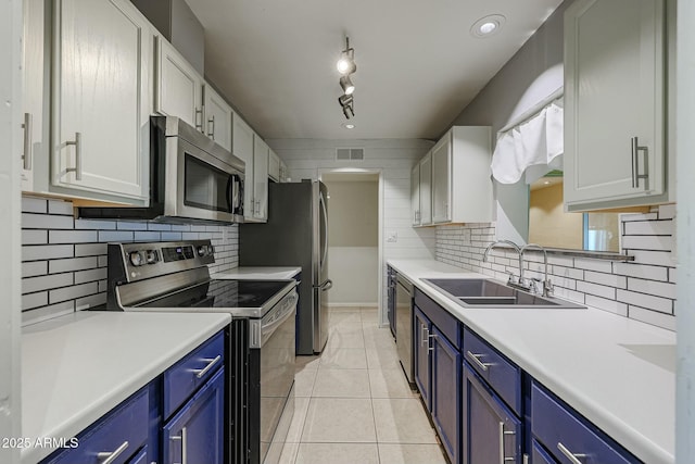 kitchen with white cabinets, sink, blue cabinetry, and stainless steel appliances