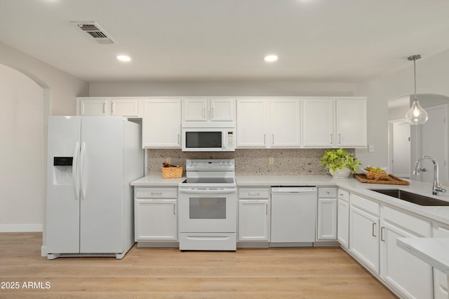 6366 W Saint John Ave, Glendale, AZ 85308 - kitchen featuring white appliances, a sink, arched walkways, white cabinetry, and tasteful backsplash