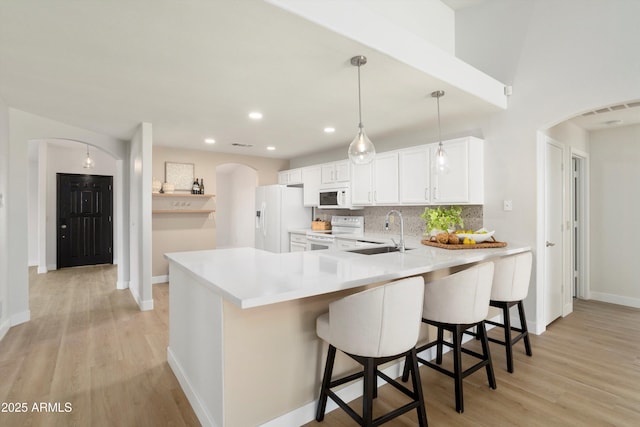 6366 W Saint John Ave, Glendale, AZ 85308 - kitchen with white appliances, a sink, arched walkways, a peninsula, and light wood-style floors