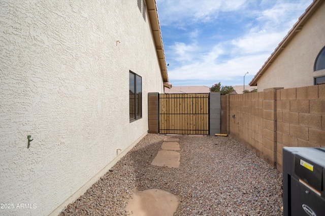 6366 W Saint John Ave, Glendale, AZ 85308 - view of side of home featuring stucco siding and a gate
