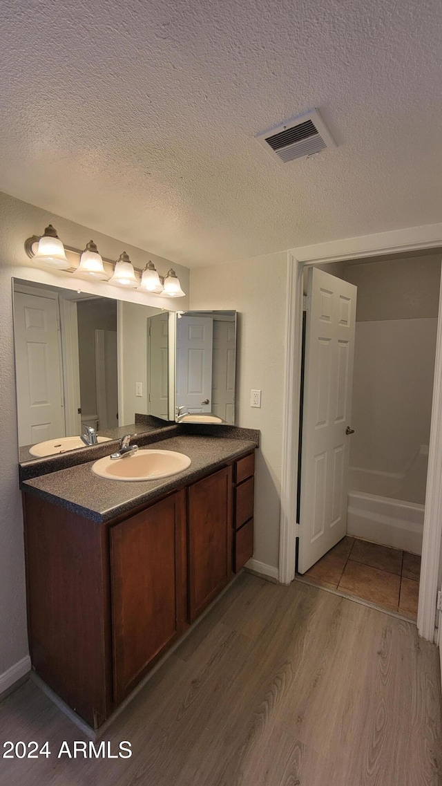 bathroom with vanity, hardwood / wood-style floors, and a textured ceiling