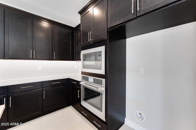 1301 W Via De Olivos, Queen Creek, AZ 85140 - kitchen with stainless steel oven, built in microwave, light tile patterned floors, tasteful backsplash, and light countertops