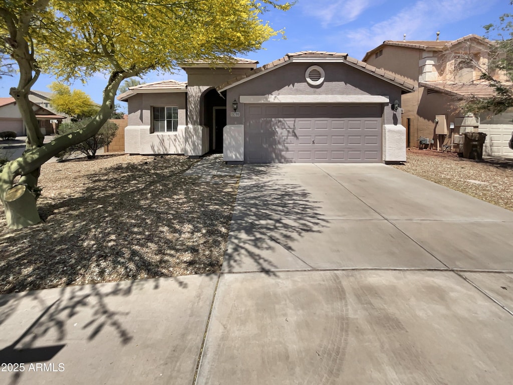 15298 W Adams St, Goodyear, AZ 85338 - view of front facade featuring a garage, a tile roof, driveway, and stucco siding