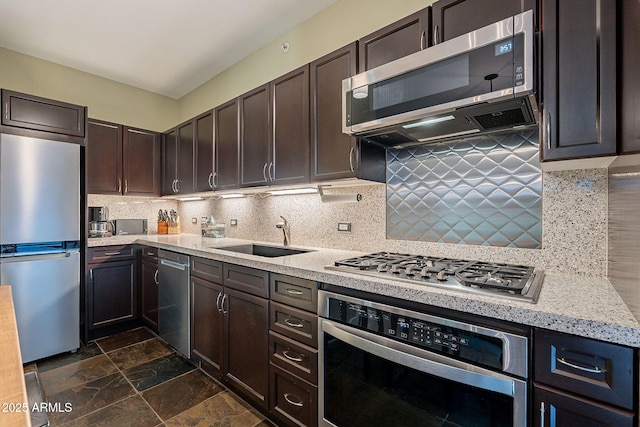 kitchen featuring stainless steel appliances, dark brown cabinets, sink, and backsplash