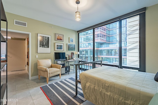 bedroom with light tile patterned floors and a wall of windows