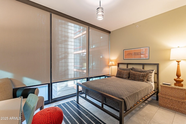 bedroom with light tile patterned flooring, floor to ceiling windows, and multiple windows