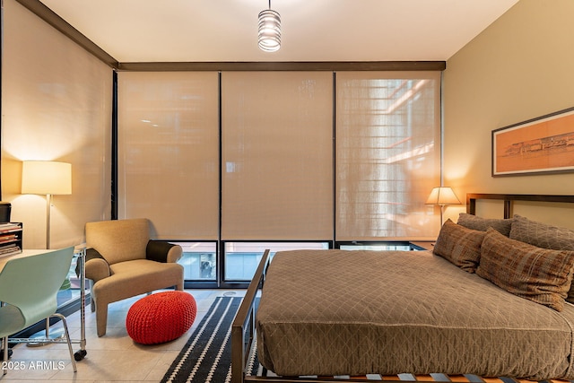 tiled bedroom featuring a wall of windows