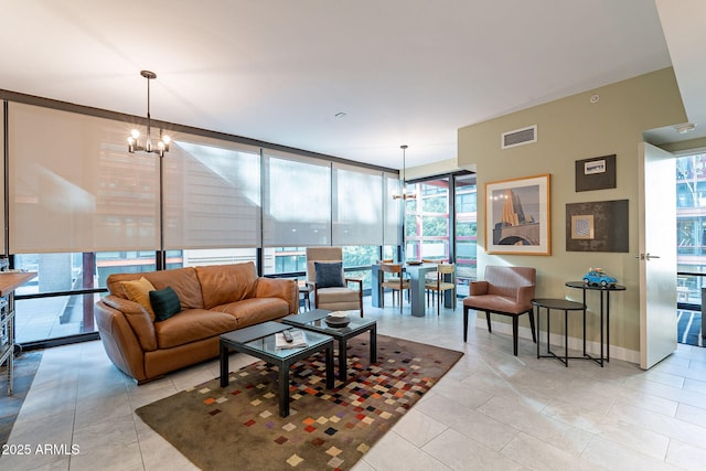 living room with an inviting chandelier, a wall of windows, and light tile patterned flooring