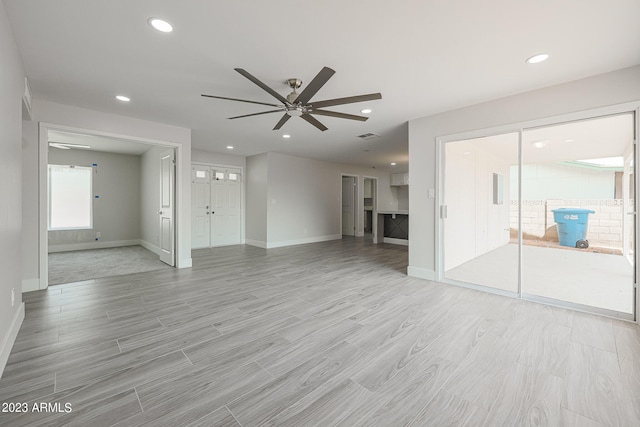 unfurnished living room with ceiling fan