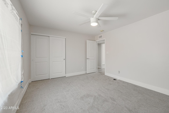 unfurnished bedroom with carpet flooring, ceiling fan, and a closet