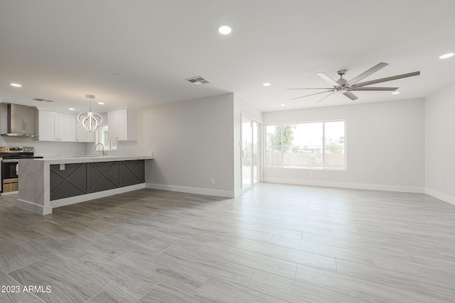 unfurnished living room featuring ceiling fan and sink