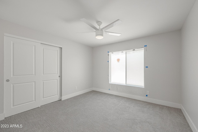 unfurnished bedroom featuring light colored carpet, ceiling fan, and a closet