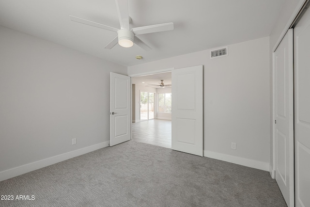 unfurnished bedroom featuring ceiling fan, a closet, and carpet floors