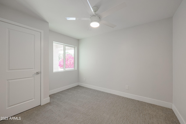 carpeted spare room with ceiling fan