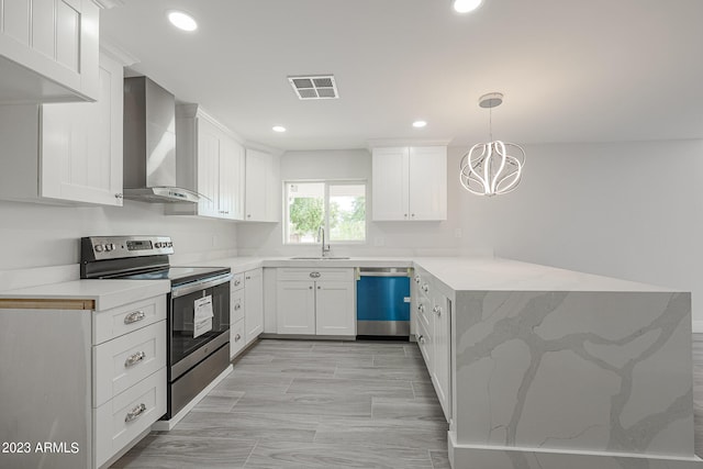 kitchen featuring stainless steel appliances, sink, decorative light fixtures, white cabinets, and wall chimney exhaust hood