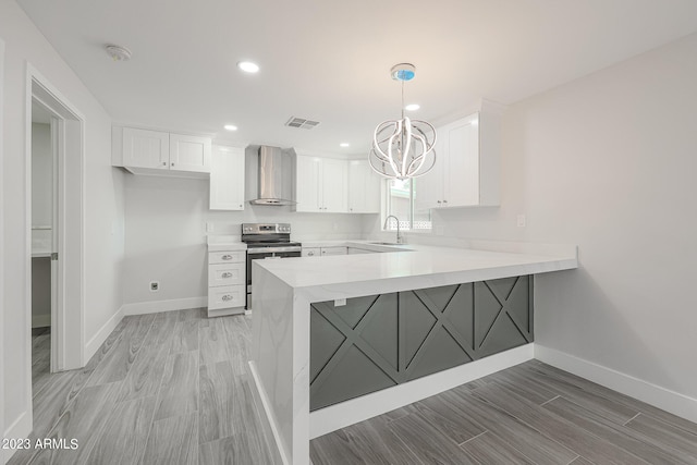 kitchen featuring wall chimney range hood, electric stove, white cabinetry, and kitchen peninsula