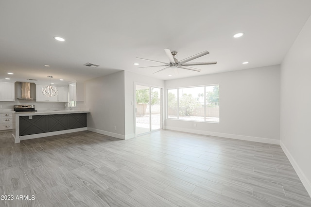 unfurnished living room featuring ceiling fan and sink