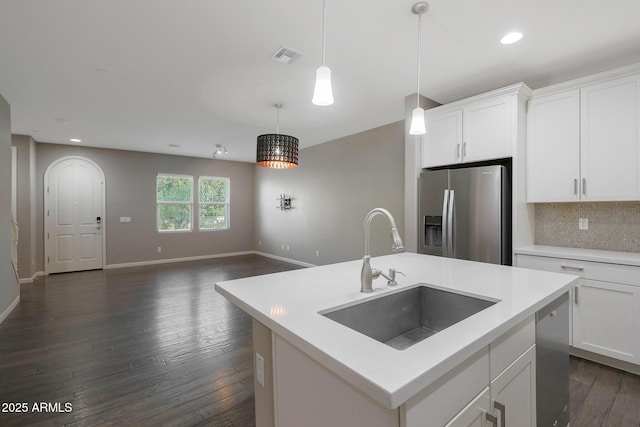 kitchen with sink, a center island with sink, pendant lighting, stainless steel appliances, and white cabinets