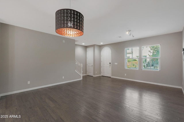 unfurnished room with dark hardwood / wood-style floors and a chandelier