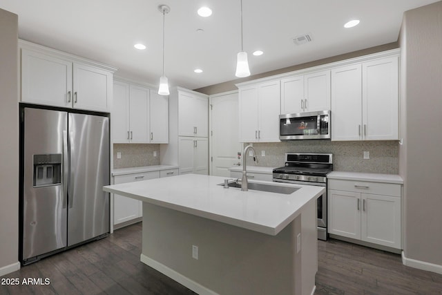 kitchen with white cabinetry, an island with sink, dark hardwood / wood-style flooring, hanging light fixtures, and stainless steel appliances