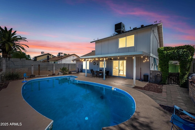 4136 W Hearn Rd, Phoenix, AZ 85053 - pool at dusk featuring a patio area, a fenced backyard, and central air condition unit