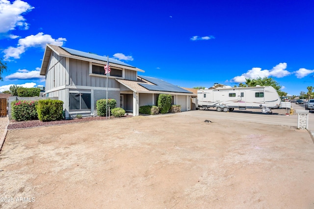 4136 W Hearn Rd, Phoenix, AZ 85053 - view of front of home featuring solar panels, a garage, and board and batten siding
