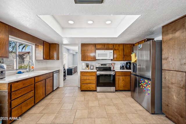 4136 W Hearn Rd, Phoenix, AZ 85053 - kitchen with stainless steel appliances, a sink, light countertops, a textured ceiling, and brown cabinets