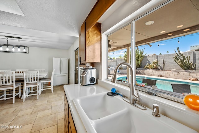 4136 W Hearn Rd, Phoenix, AZ 85053 - detailed view of freestanding refrigerator, a sink, and brown cabinetry