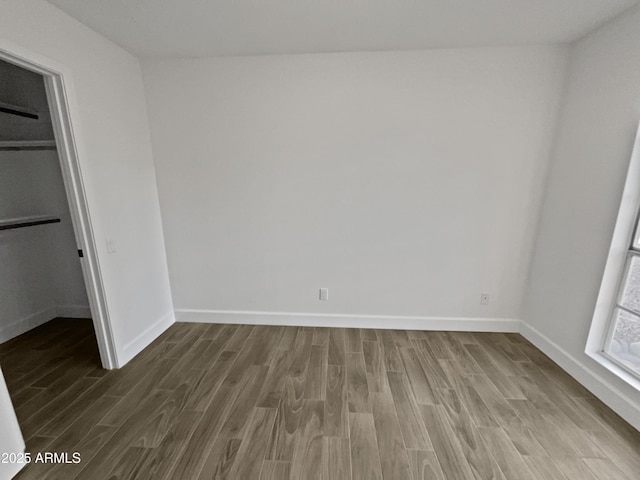 unfurnished bedroom with baseboards and wood finished floors