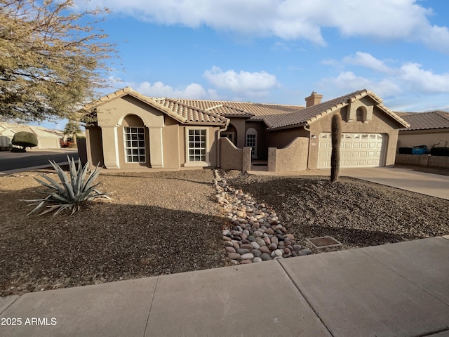 mediterranean / spanish house with an attached garage, stucco siding, concrete driveway, and a tiled roof