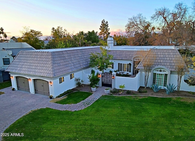 view of front of home featuring a garage and a yard